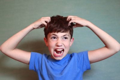 The boy with brown hair wearing a  blue shirt is excessively itching because he has head lice. 